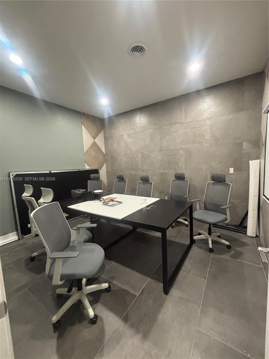 Large-format tile flooring, oversized wall tile feature panel, and recessed ceiling lighting