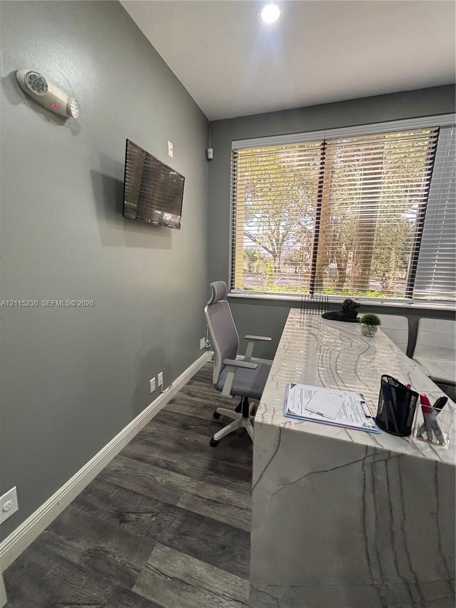 Room featuring wood-finish flooring, recessed lighting, and a large horizontal window equipped with adjustable blinds