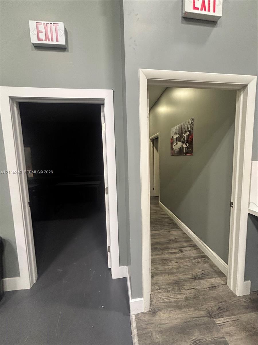 Interior space featuring dual doorways with white trim, wood-finish flooring, and recessed lighting