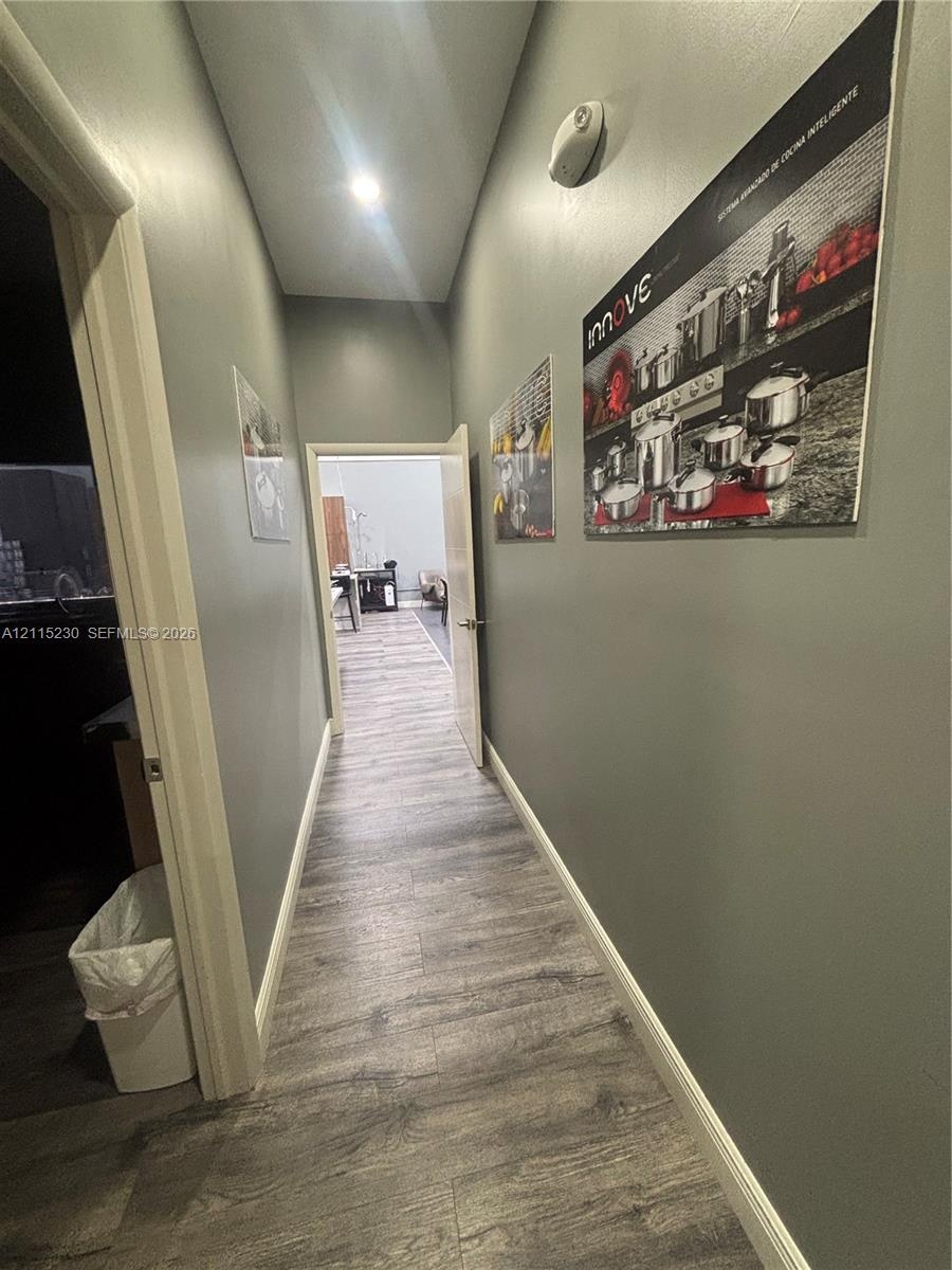 Hallway featuring wood-finish flooring, neutral-toned walls, and recessed ceiling lighting