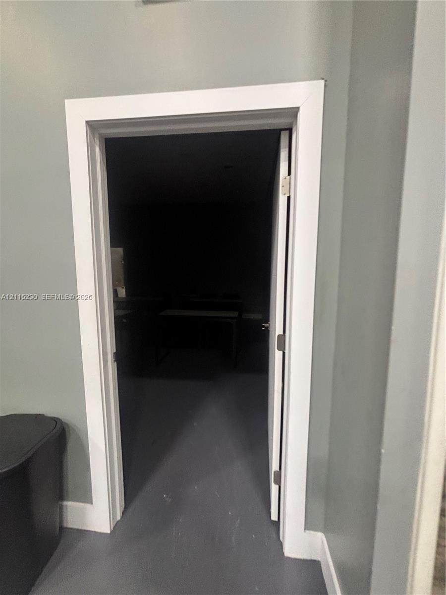 Interior doorway featuring crisp white trim, a solid-core door, and brushed metal hinges