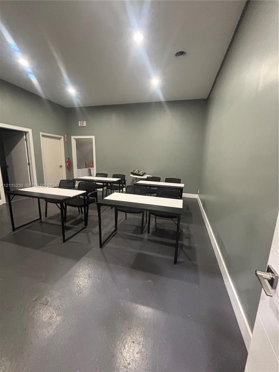 Interior space featuring neutral wall paint, recessed lighting, and solid-surface flooring