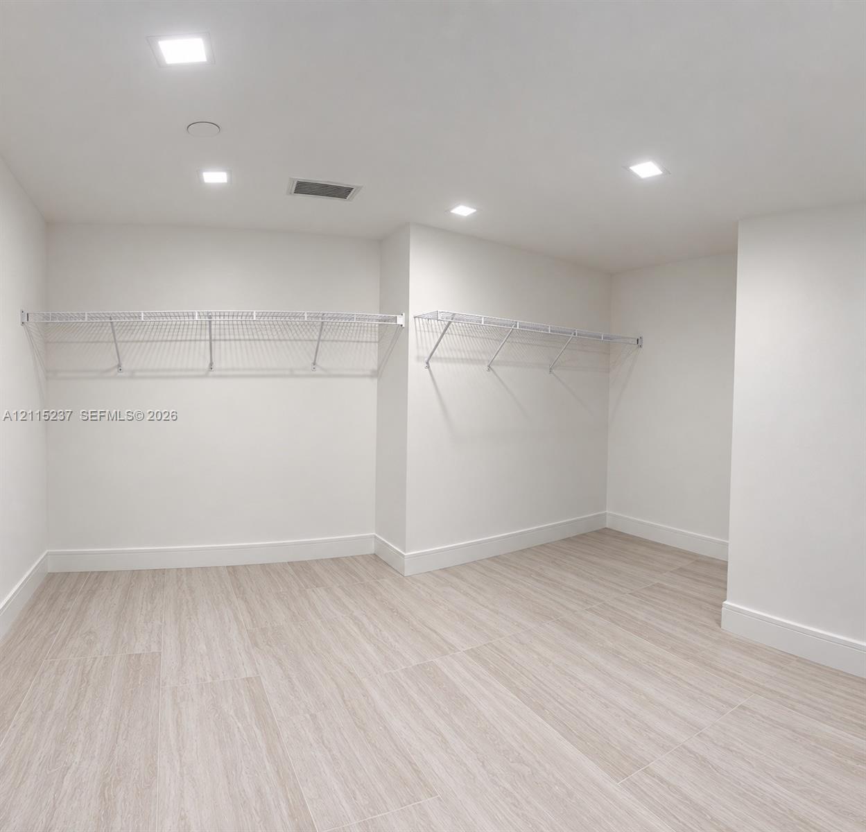 Neutral-toned wood-finish flooring, recessed lighting, and white coated wire shelving