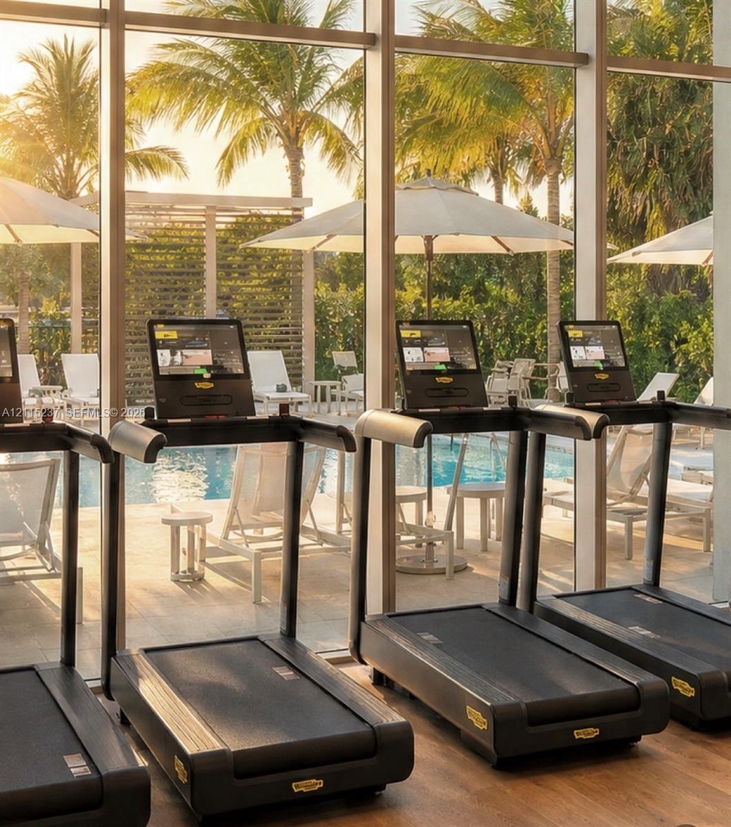 Fitness center featuring floor-to-ceiling windows and wood-finish flooring