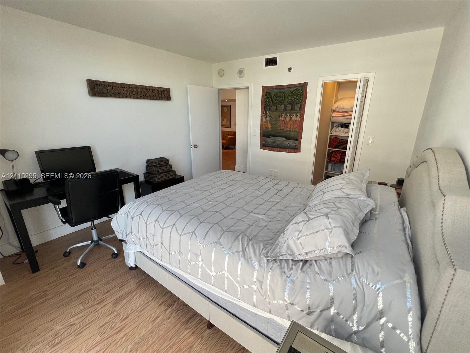 Wood-finish flooring, neutral wall finishes, and a reach-in closet with bifold doors