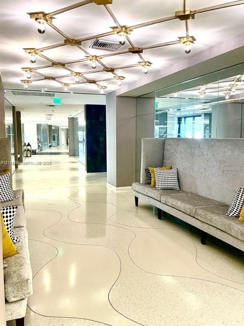 Custom grid-pattern overhead light fixture, polished terrazzo flooring with inlaid curvilinear detailing, and floor-to-ceiling mirror paneling