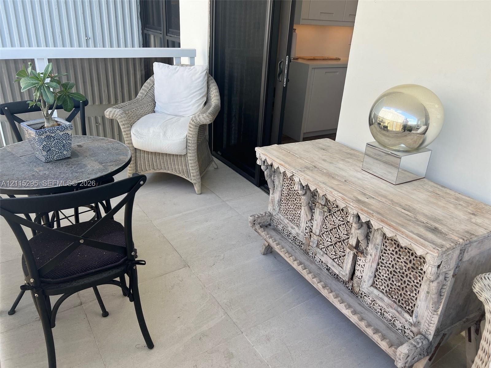 Covered balcony featuring large-format stone-finish floor tiles and white metal railing