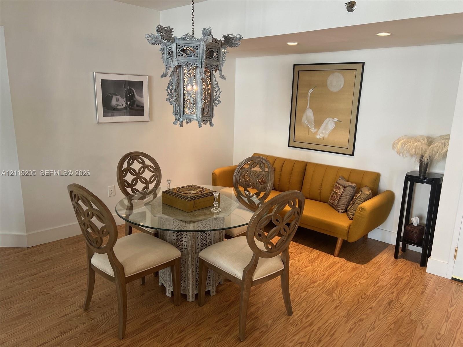 Wood-finish flooring, recessed lighting, and ornate metal chandelier