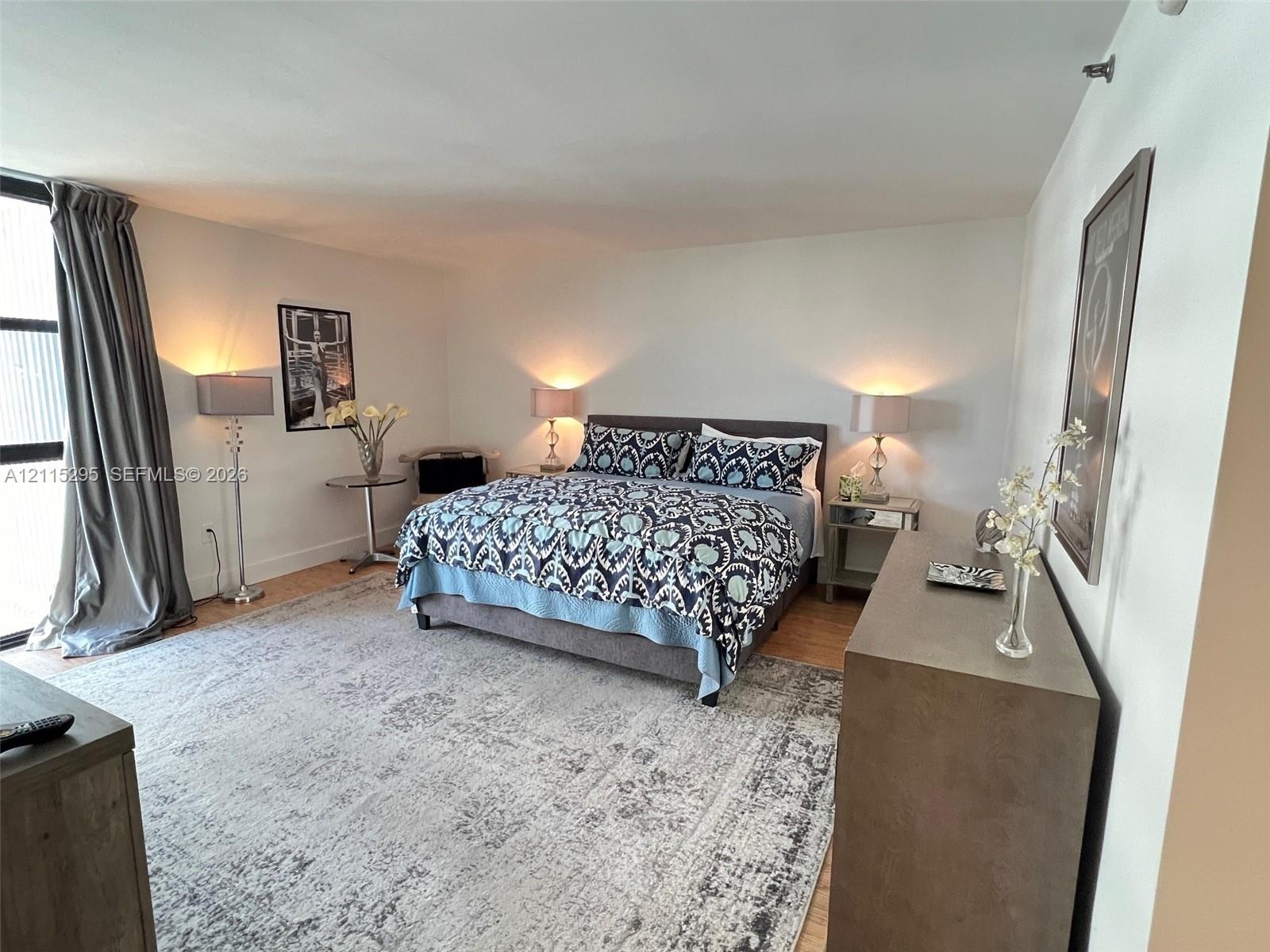 Spacious room featuring wood-finish flooring and floor-to-ceiling windows