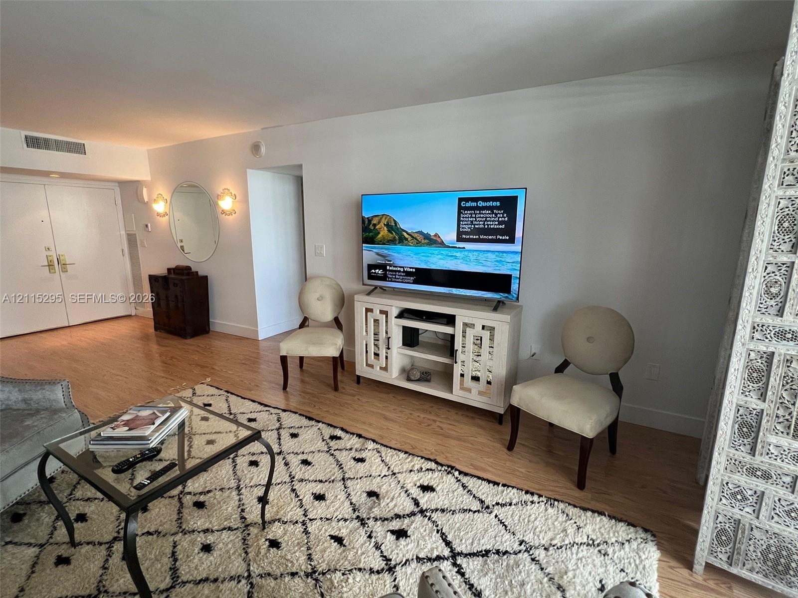 Wood-finish flooring, dual-door entry, and wall-mounted decorative lighting fixtures
