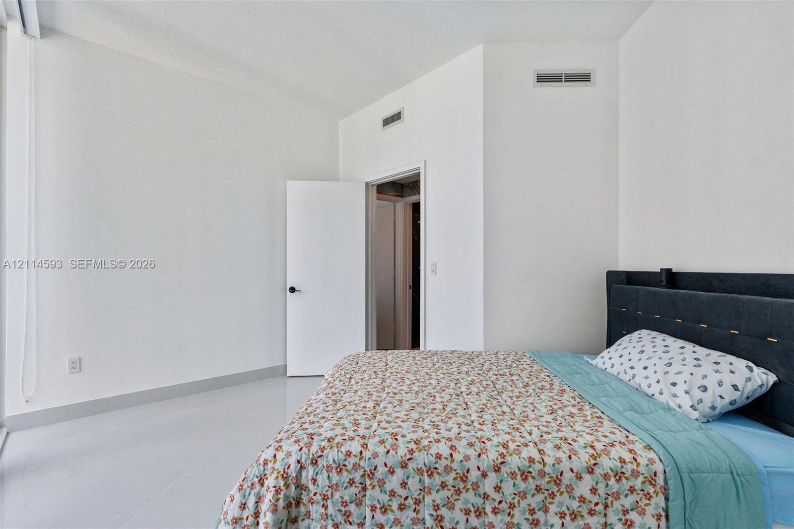Vaulted ceilings, neutral wall color, and polished hard-surface flooring