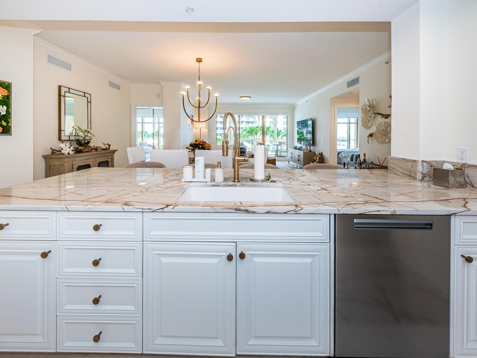 Custom Cucina with a Grand Peninsula, Quartzite Counter & Backsplash Accessorized Stainless Appliances.