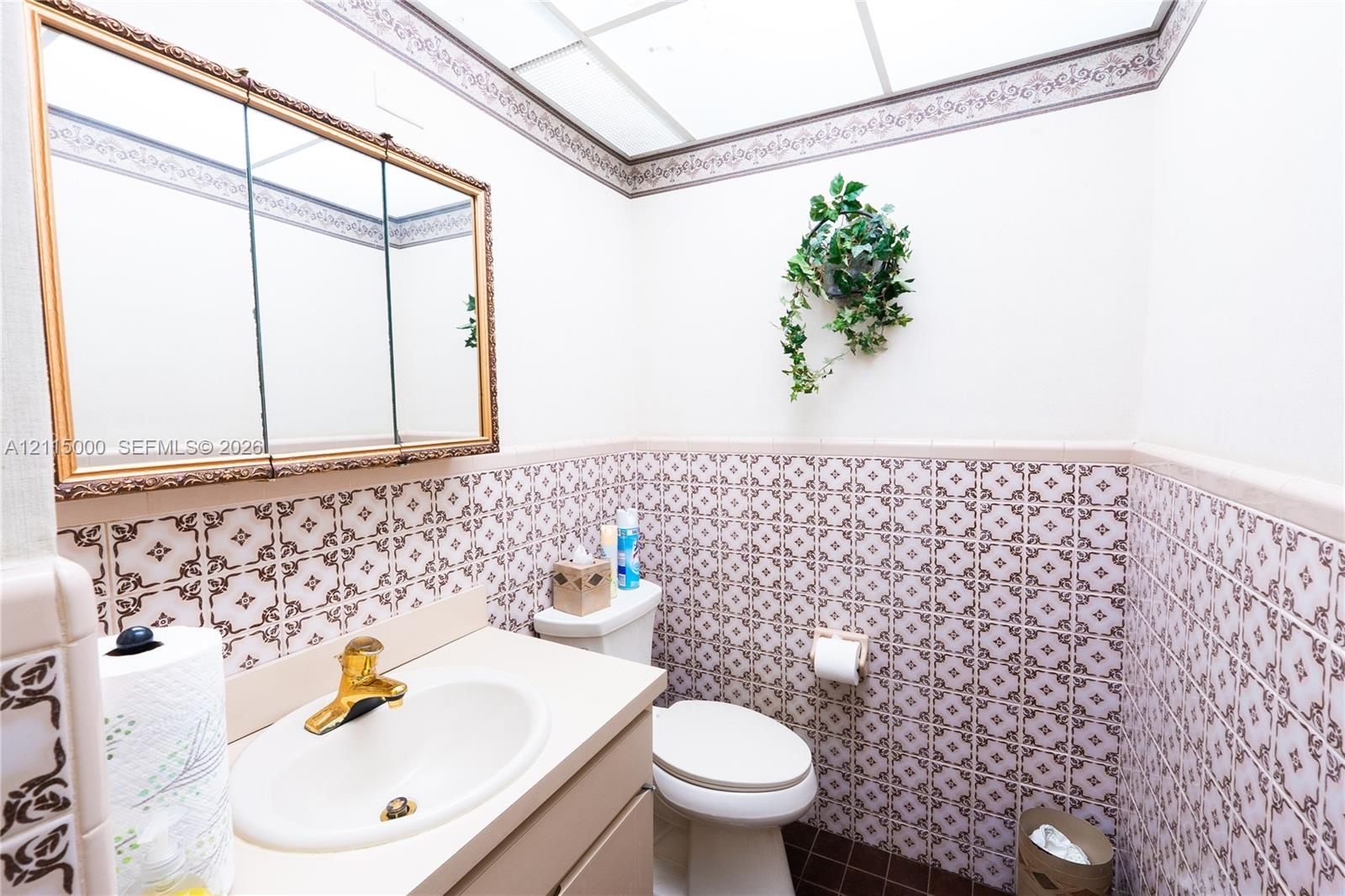 Built-in floor-to-ceiling wooden shelving and dual rectangular surface-mount lighting fixtures