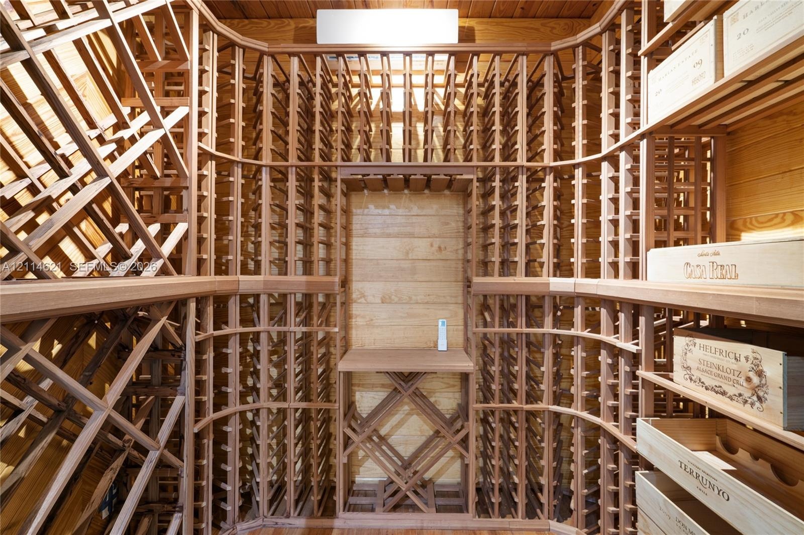 Custom built-in wood wine racking with individual bottle storage, diamond-patterned bins, and a central display shelf