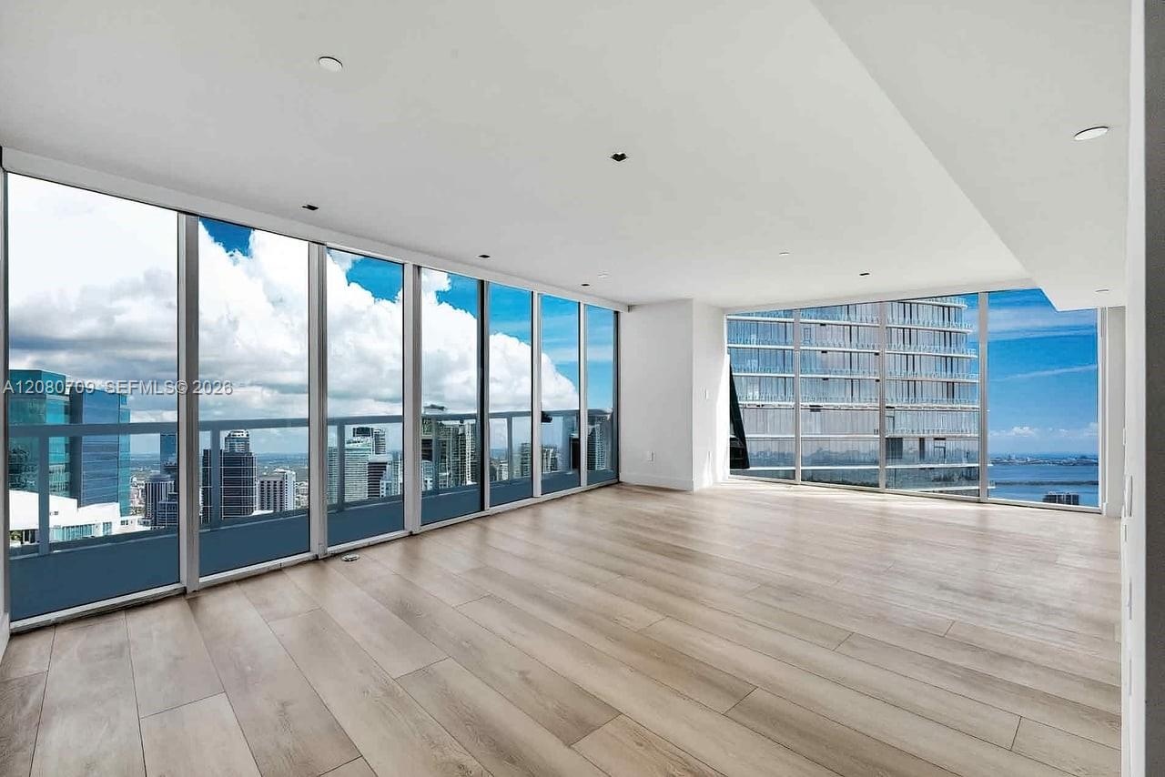 Open-concept interior featuring large-format tile flooring, stone-topped kitchen island, built-in cabinetry with integrated under-cabinet lighting, an