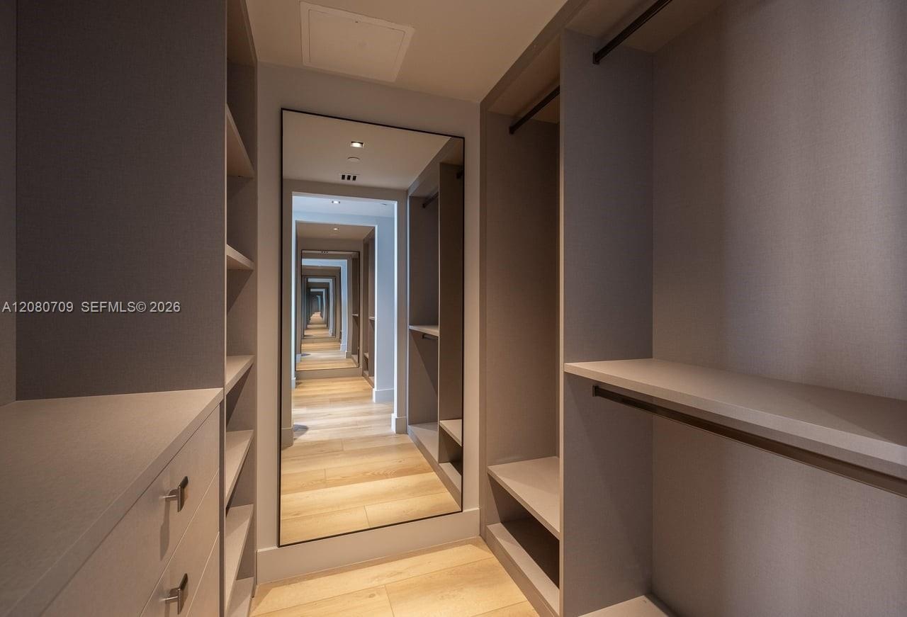 Interior space featuring wood-finish flooring, floor-to-ceiling glass sliding doors, and a tiled private terrace