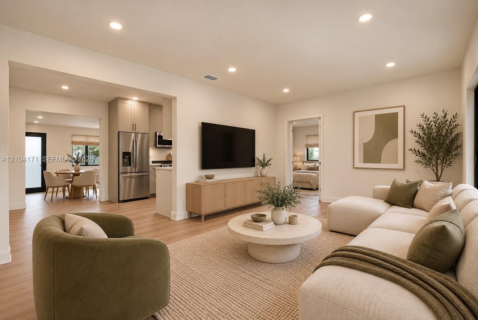 Open-concept living space featuring wood-finish flooring, recessed lighting, and stainless steel kitchen appliances