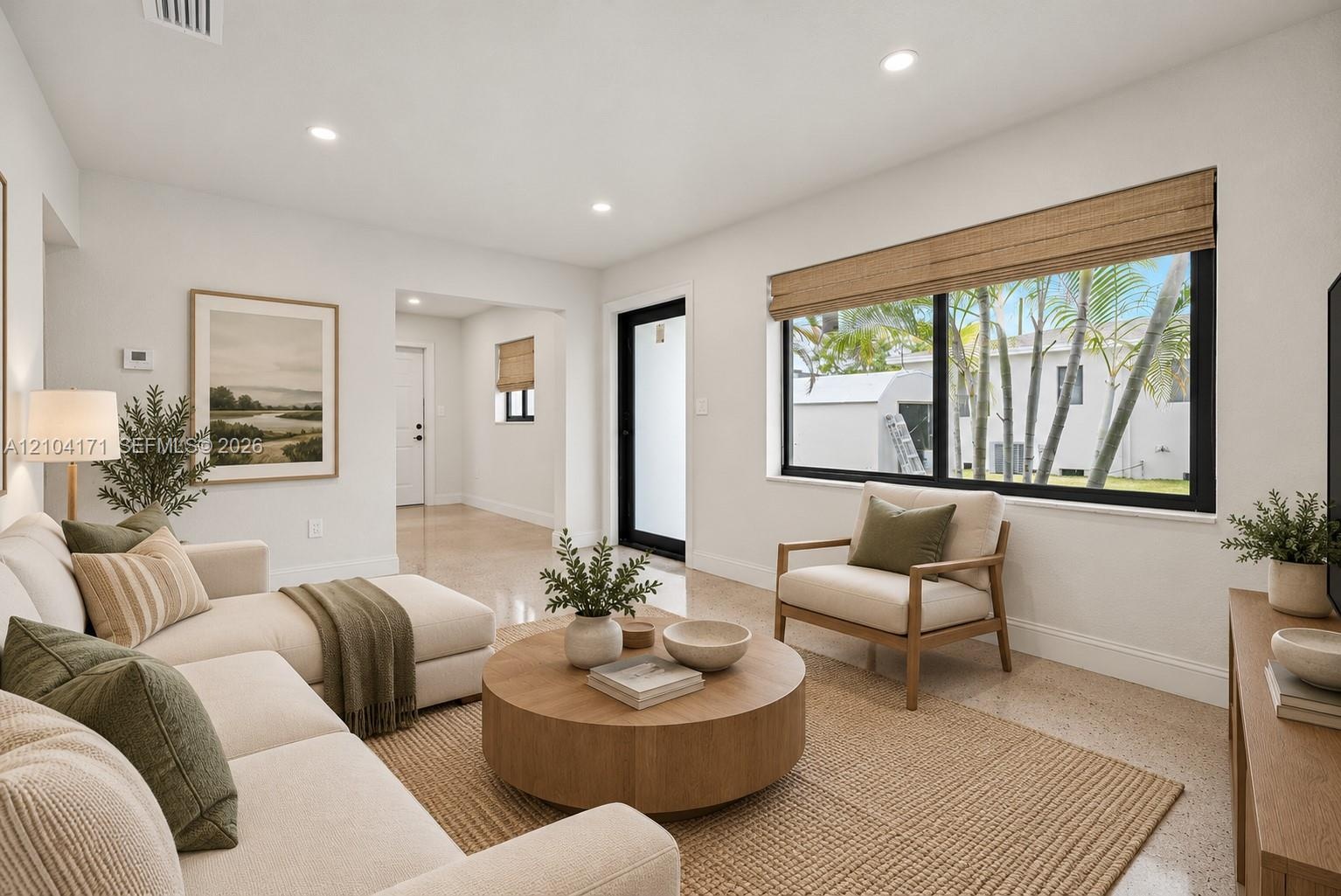 Bright living area featuring recessed lighting, large windows with black frames, and light-toned hard-surface flooring