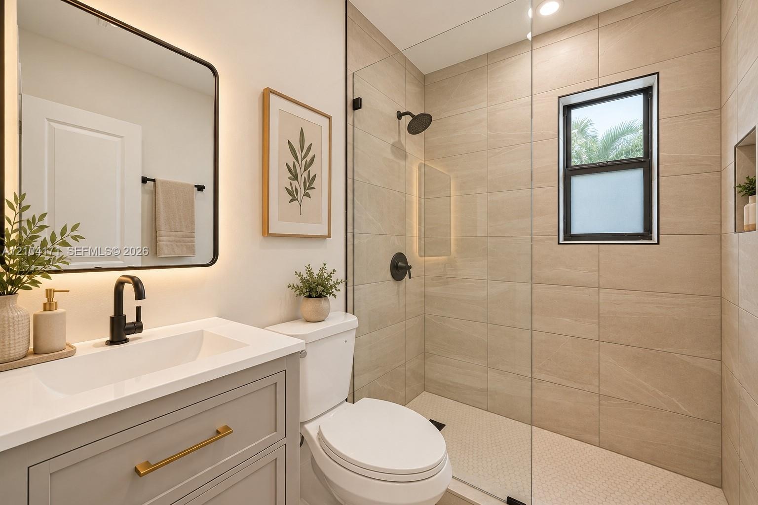 Bathroom featuring a light grey vanity with a white countertop, matte black fixtures, a walk-in shower with floor-to-ceiling tile, and a backlit recta
