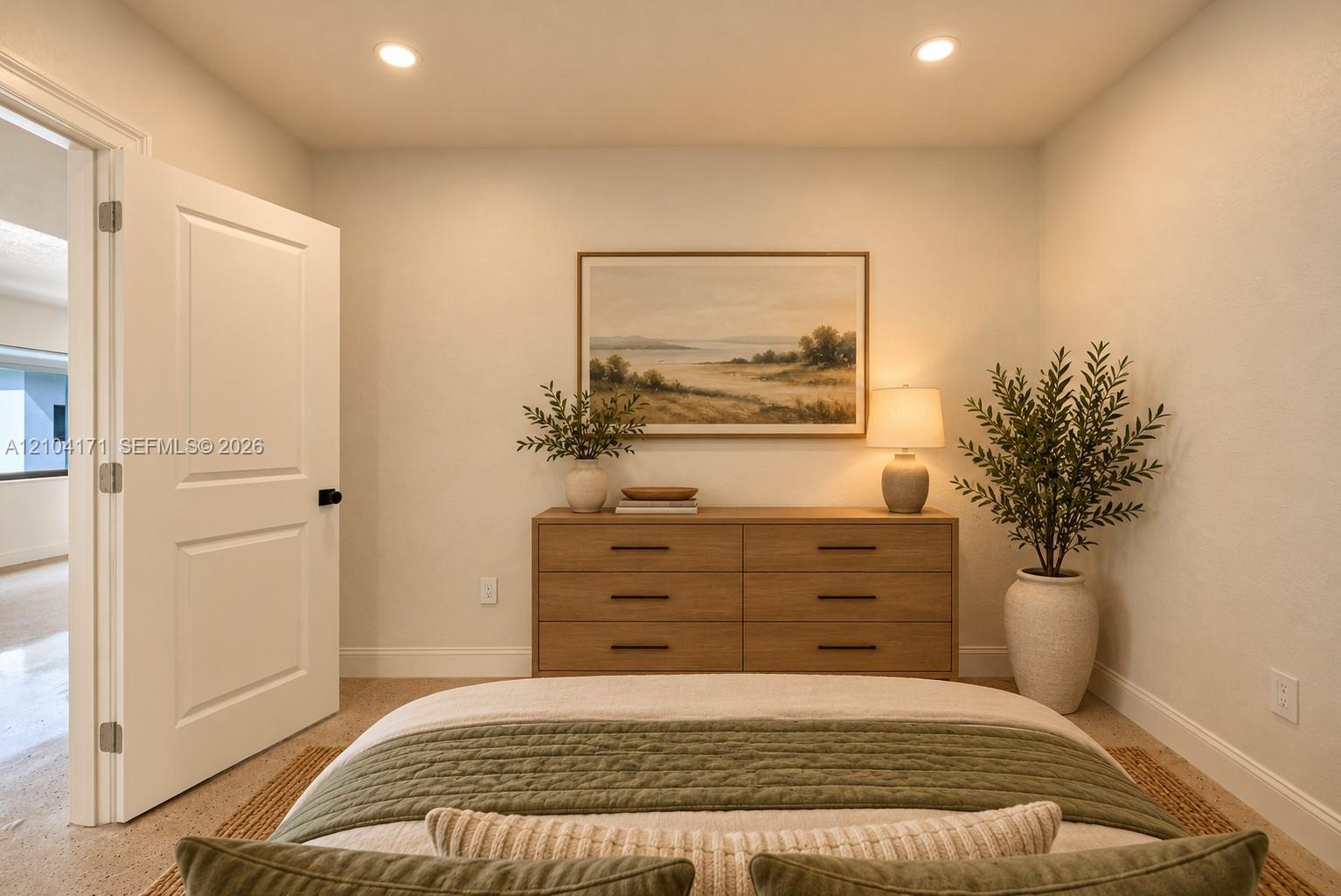 Side yard featuring a smooth stucco exterior, manicured lawn, established mature tree, and perimeter privacy hedges