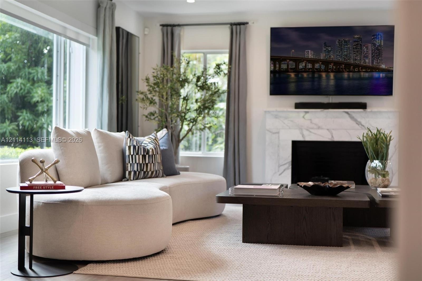 Living area featuring a floor-to-ceiling window, large-format stone fireplace surround, and recessed ceiling lighting