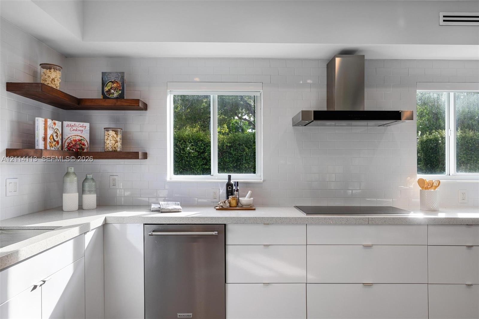Kitchen featuring white flat-panel cabinetry, stone countertops, stainless steel appliances, a stainless steel range hood, and wood-finish floating co
