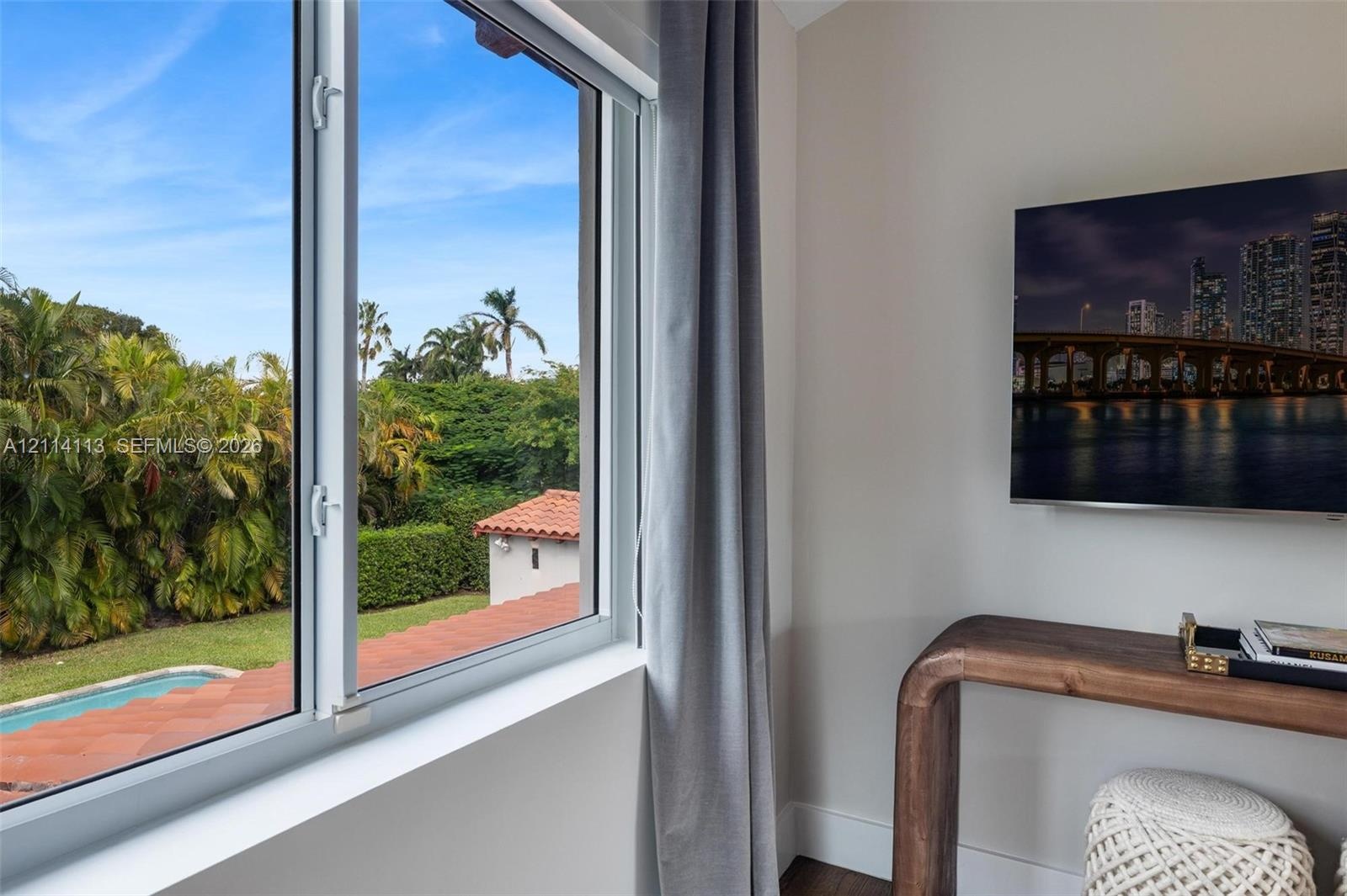 Casement window featuring white frames and custom wall-mounted television