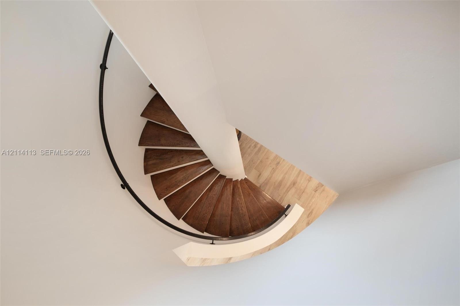 Spiral staircase featuring wood-finish treads, a central support column