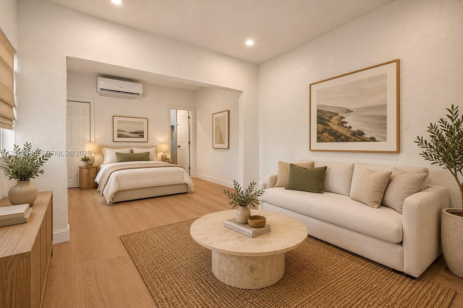 Open-concept living space featuring wood-finish flooring, recessed lighting, and a wall-mounted ductless air conditioning unit