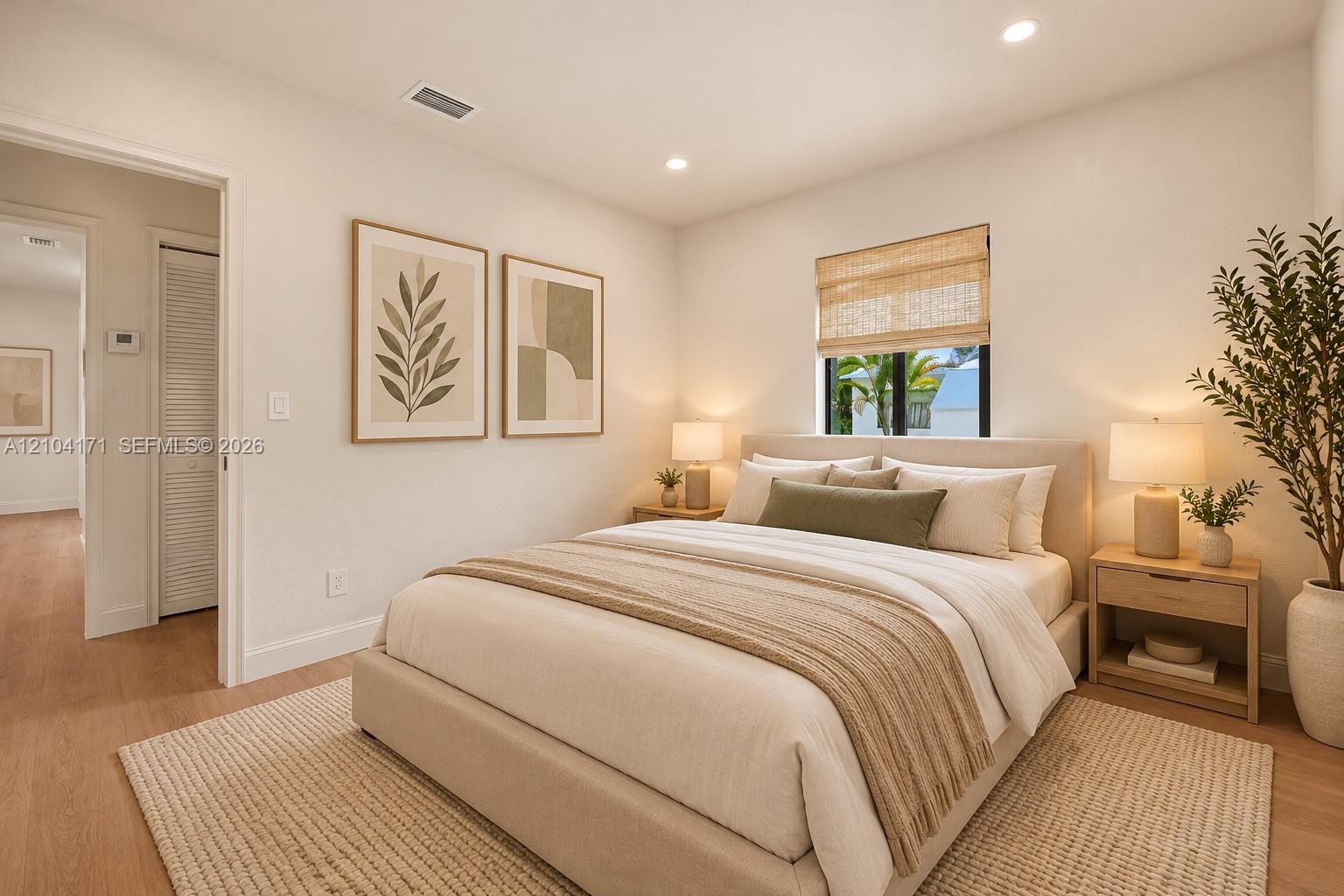 Neutral-toned bedroom featuring recessed lighting, wood-finish flooring, and a single-pane window with a woven shade