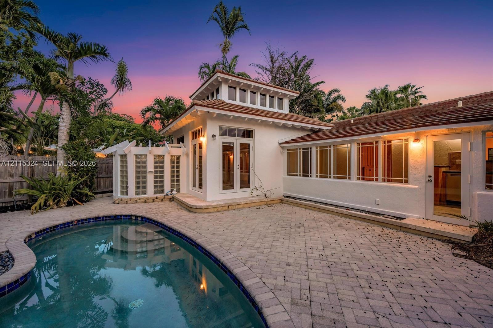 Exterior featuring a swimming pool, paved patio, stuccowork facade, cupola architectural element, and multi-light windows