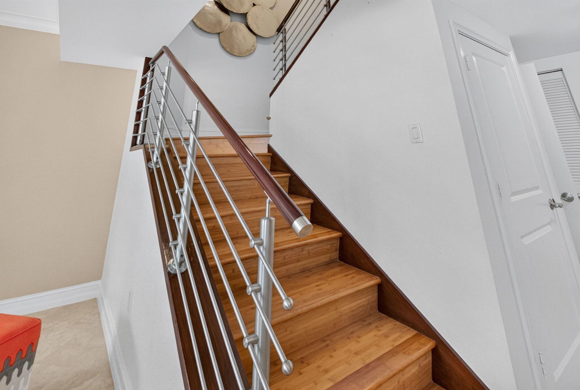 Wood-finish stairs with a stainless steel and wood railing.