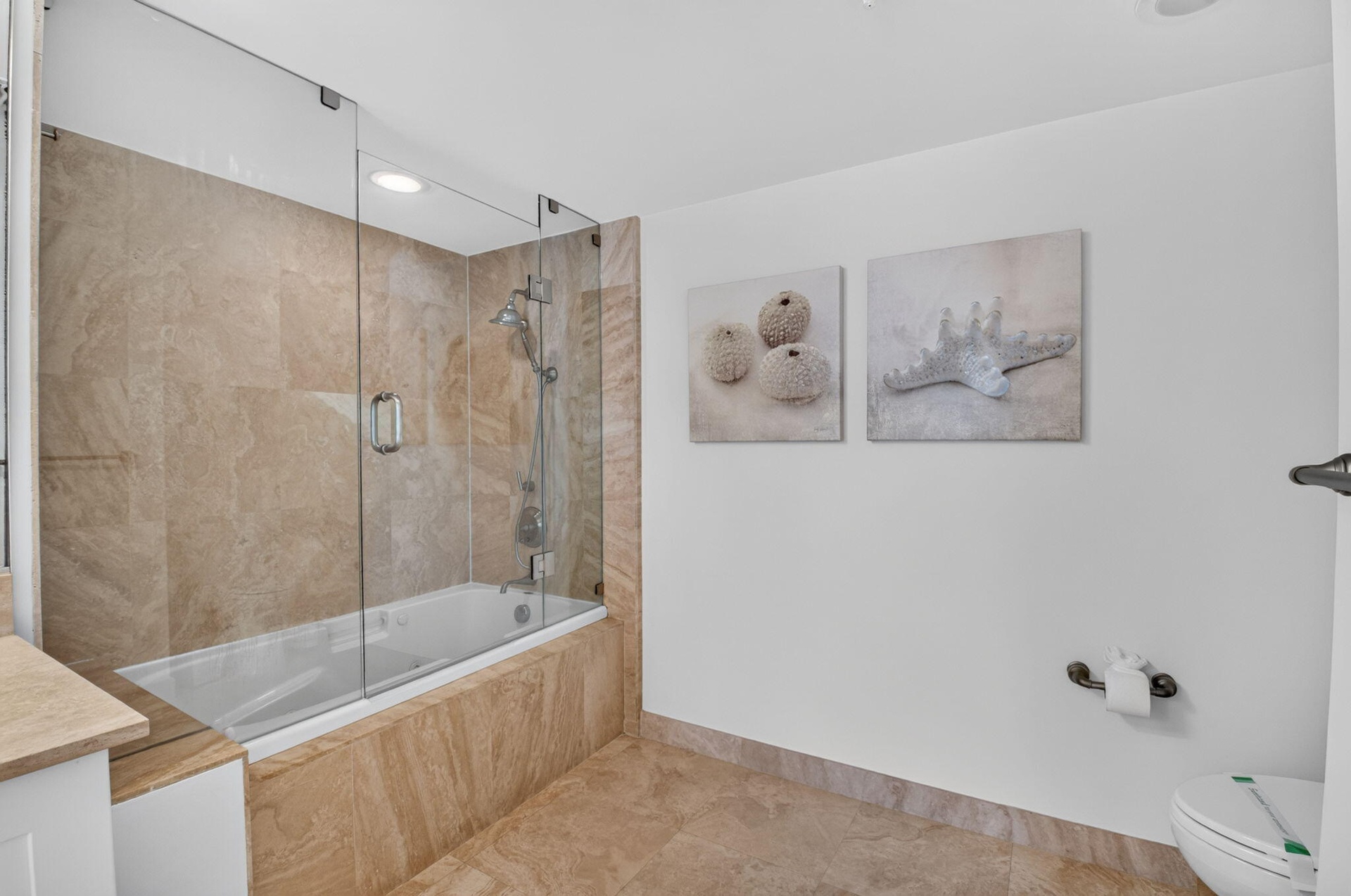 Bathtub with glass shower enclosure.