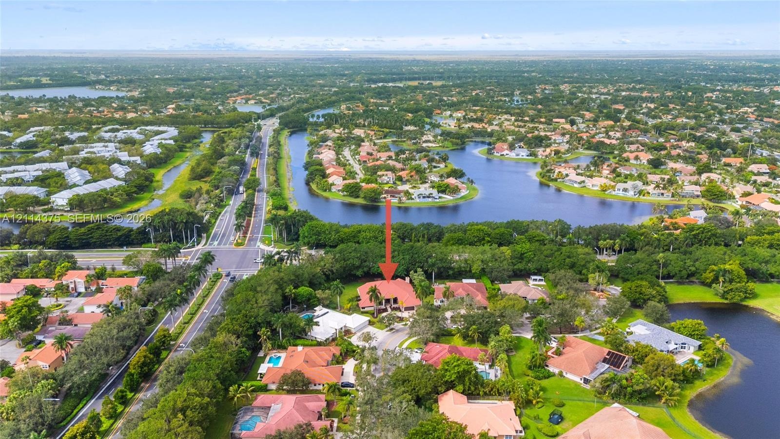 Aerial perspective of a multi-level residence featuring a clay tile roof, paved driveway, expansive lot with mature landscaping, and proximity to mult