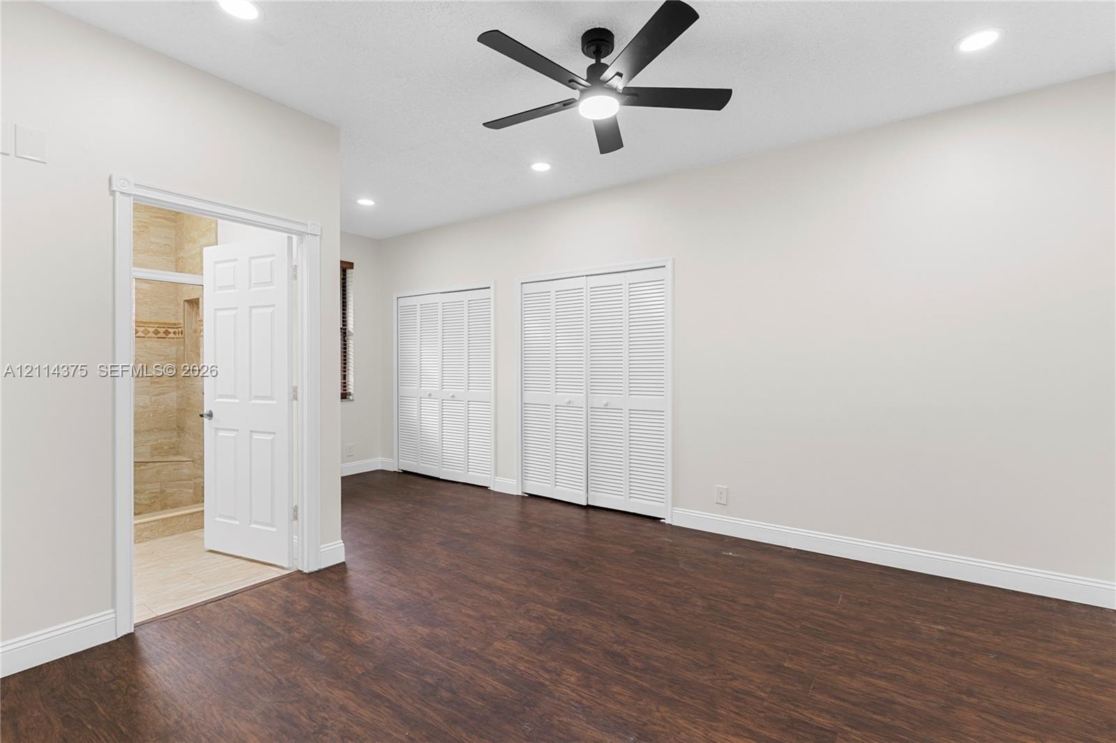 Wood-finish flooring, recessed lighting, ceiling fan with integrated light, and two sets of louvered-style closet doors