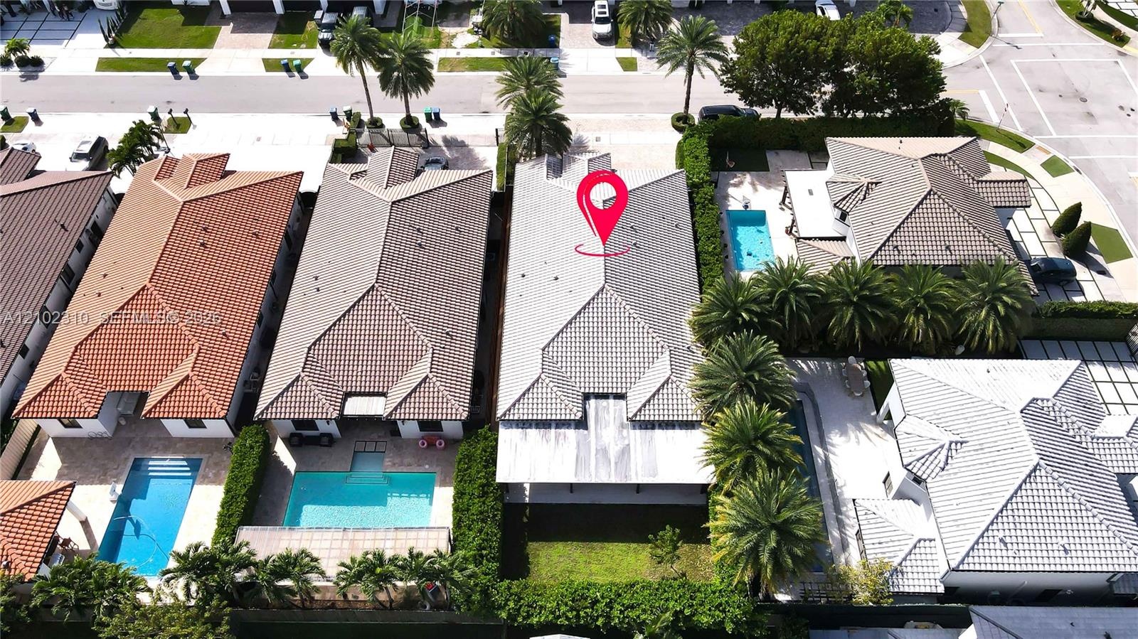 Aerial perspective featuring a concrete tile roof, covered rear patio, and expansive lawn area within a residential setting