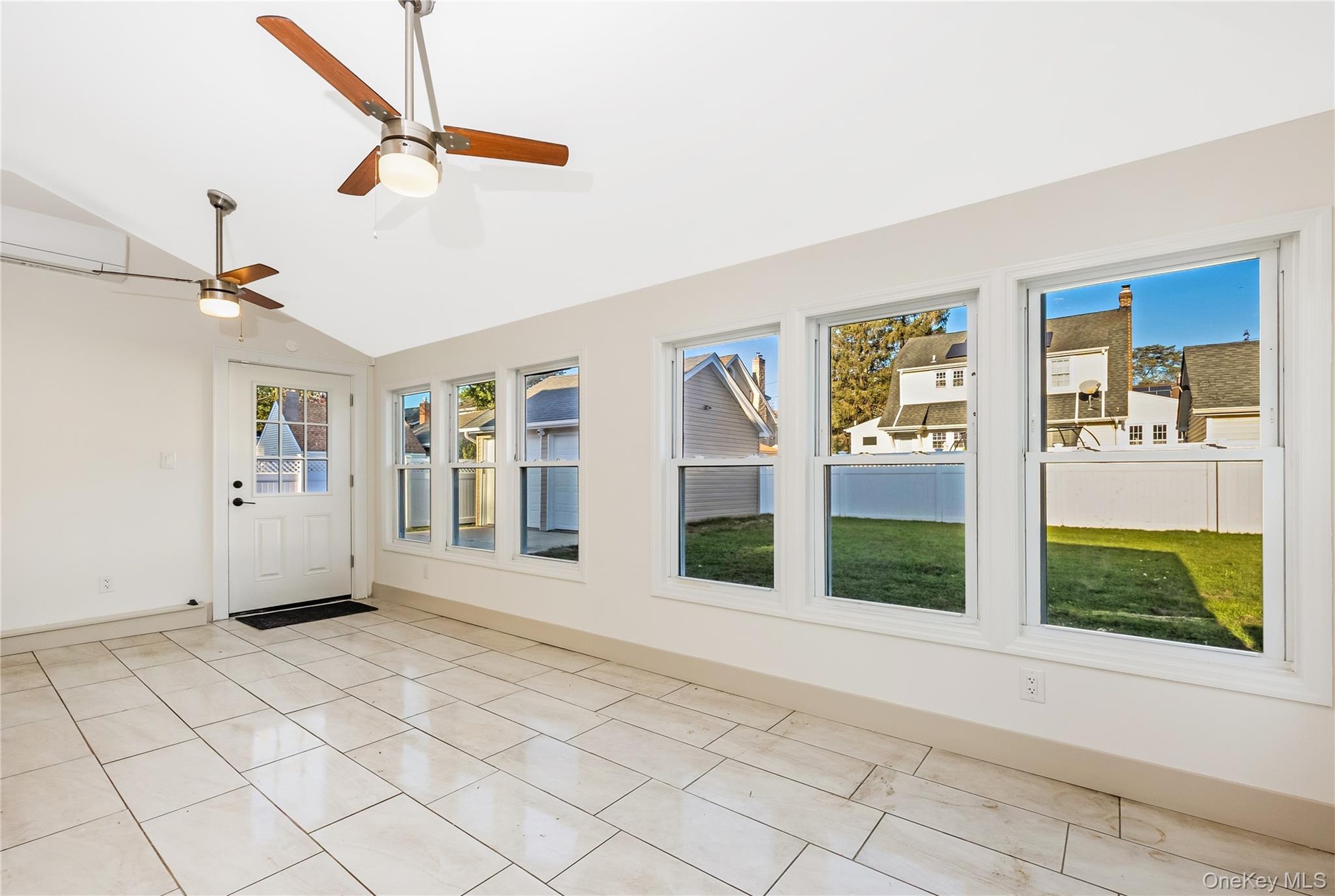 All seasons room surrounded by oversized windows, ceramic tile flooring, and a ceiling fan