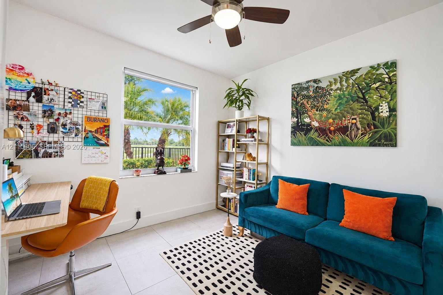 Light-filled room featuring neutral tile flooring, a large window, and an integrated ceiling fan with light fixture