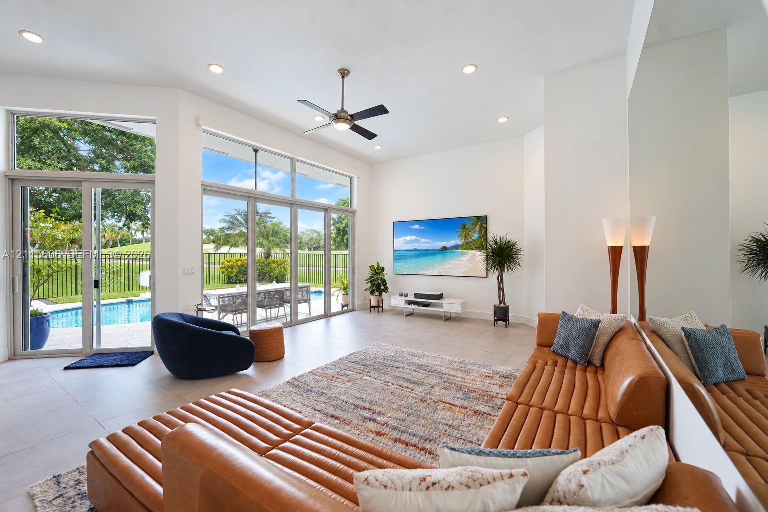 Expansive living area featuring vaulted ceilings, oversized floor-to-ceiling windows, porcelain tile flooring, recessed lighting, and a modern ceiling