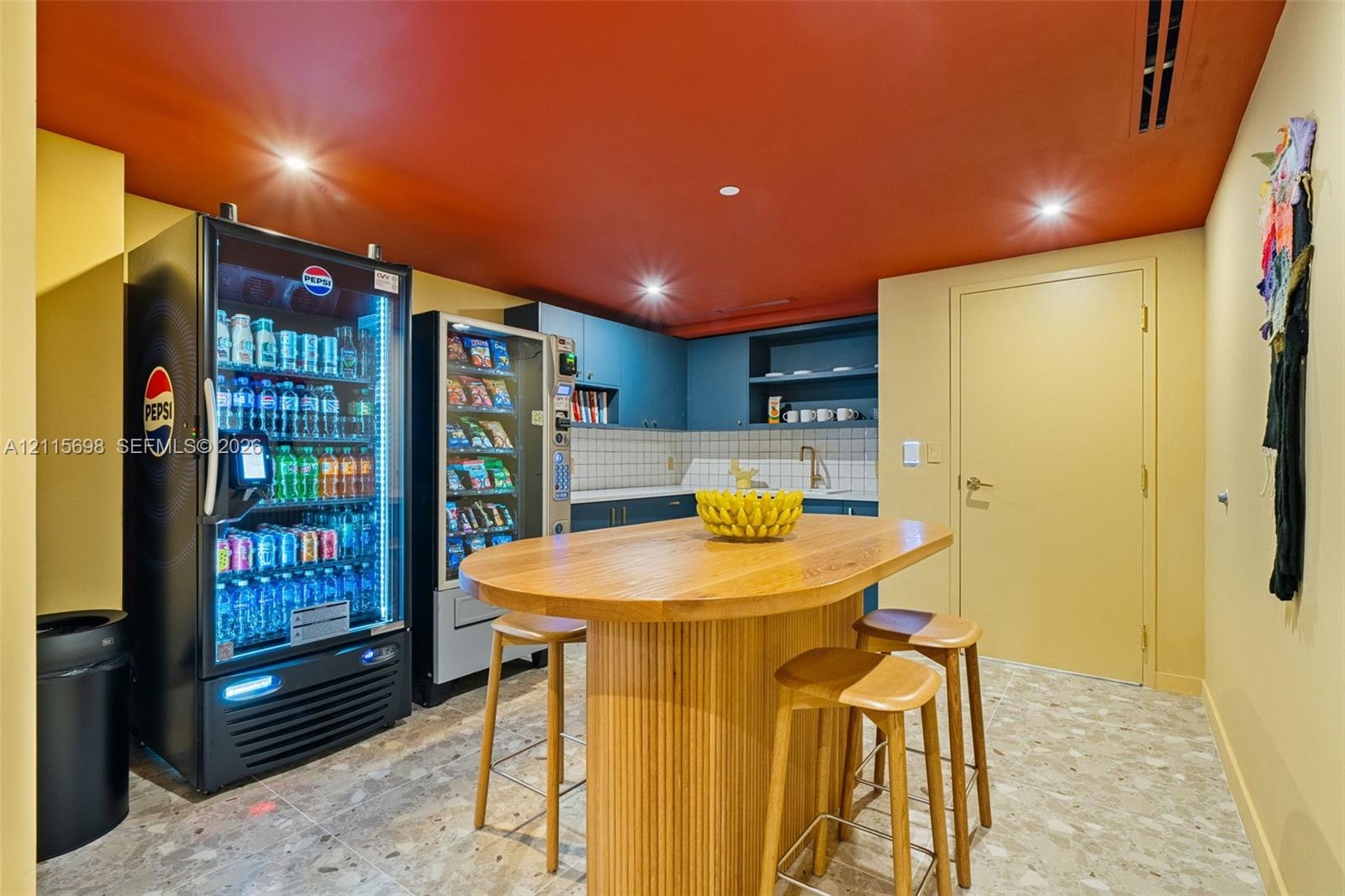 Built-in cabinetry with integrated shelving, matte-finish square tile backsplash, metallic sink faucet, and stone-finish tile flooring - building amen