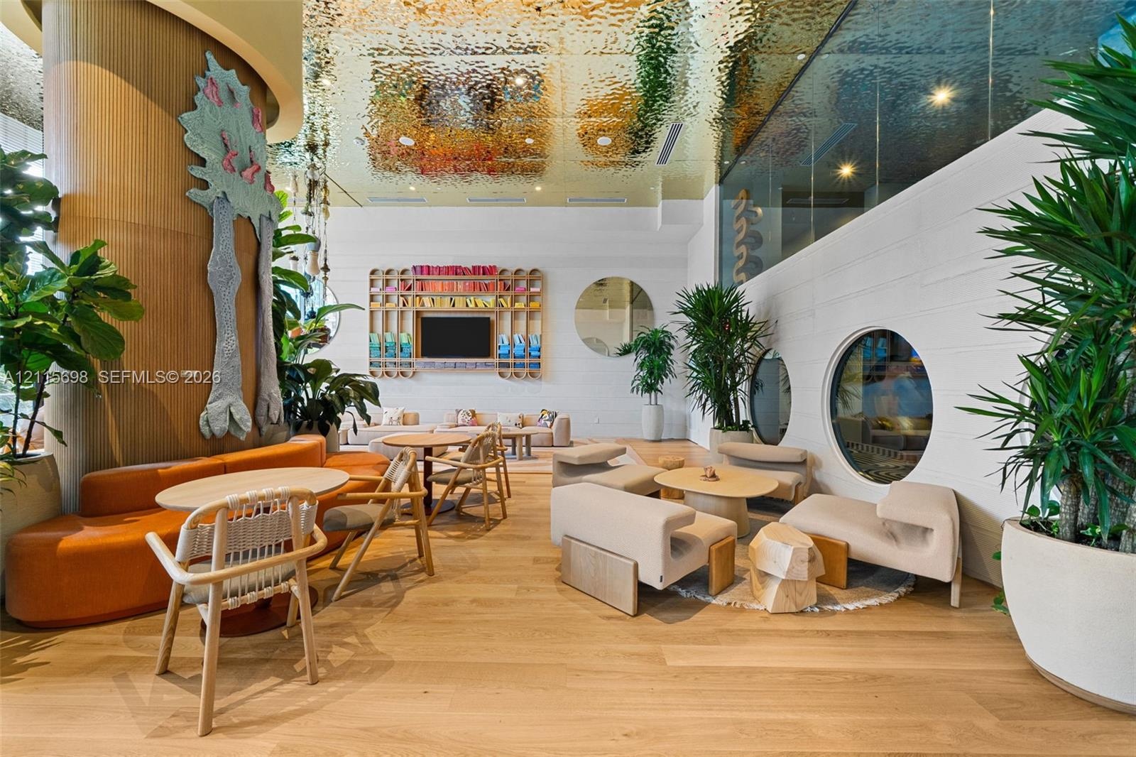 Metallic textured ceiling, wood-finish flooring, built-in shelving, and circular wall windows