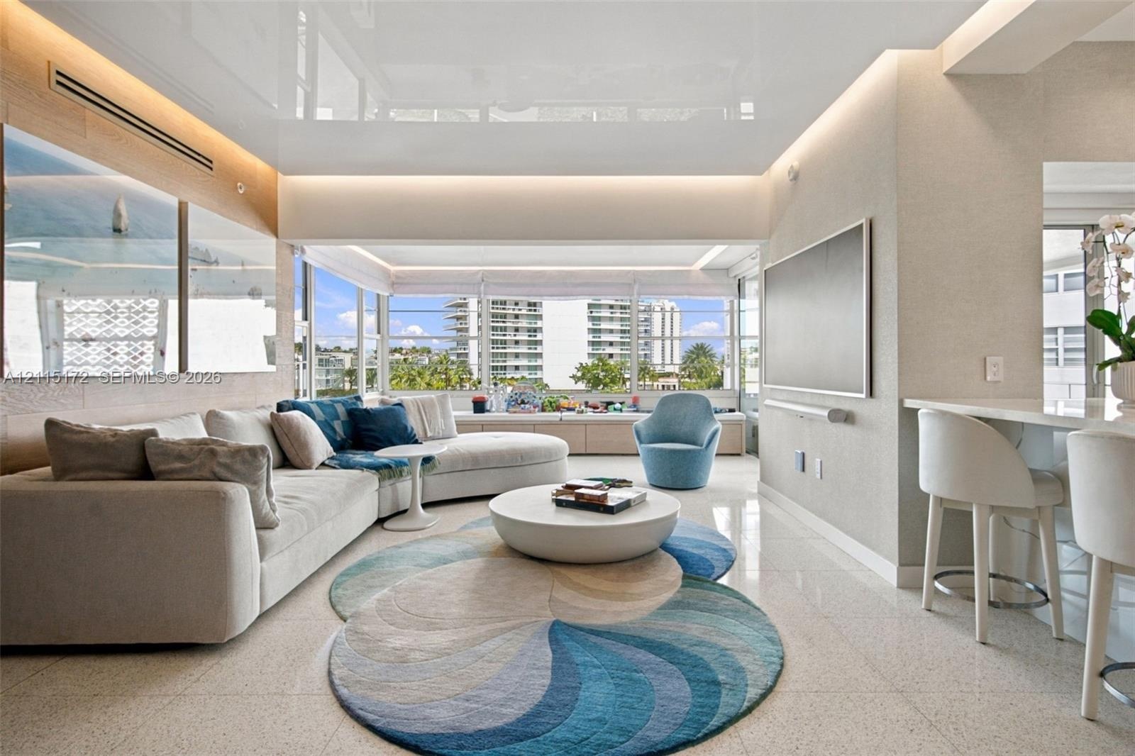 High-gloss finish ceiling with recessed accent lighting, expansive floor-to-ceiling windows, polished stone flooring, and custom built-in cabinetry