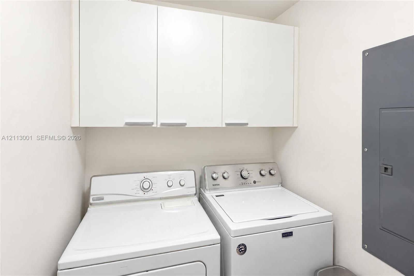 White flat-panel upper cabinetry with horizontal pulls providing overhead storage