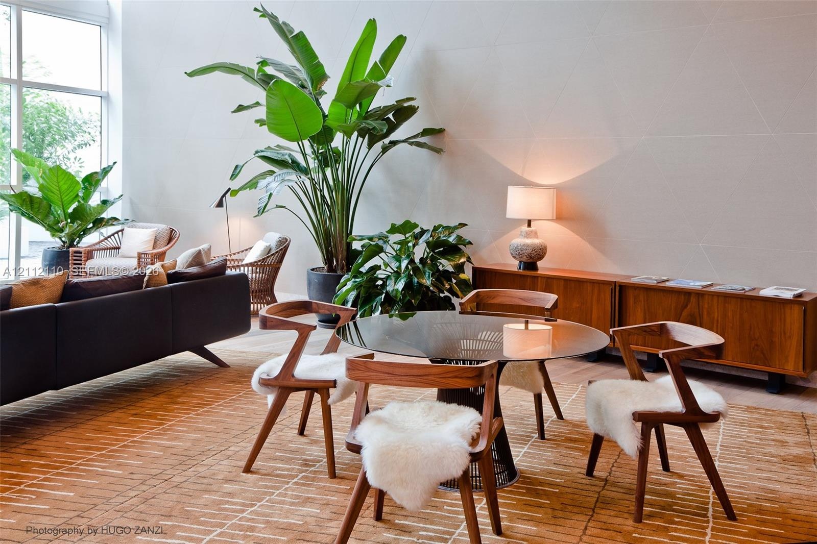 Double-height ceiling, floor-to-ceiling windows, and wall with geometric paneling