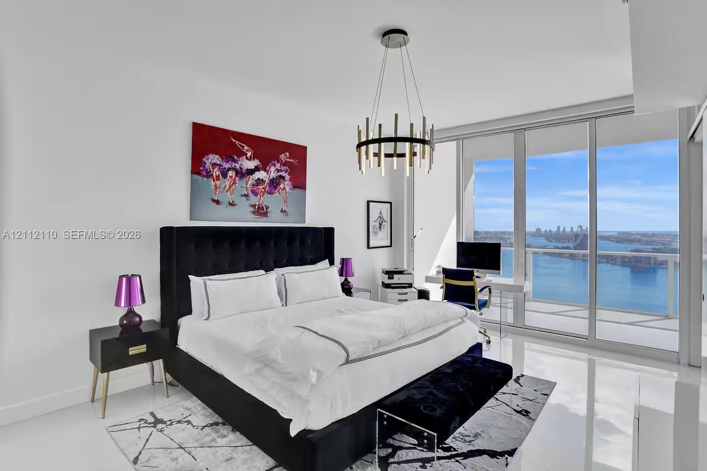 Floor-to-ceiling windows, polished stone flooring, and contemporary metal chandelier
