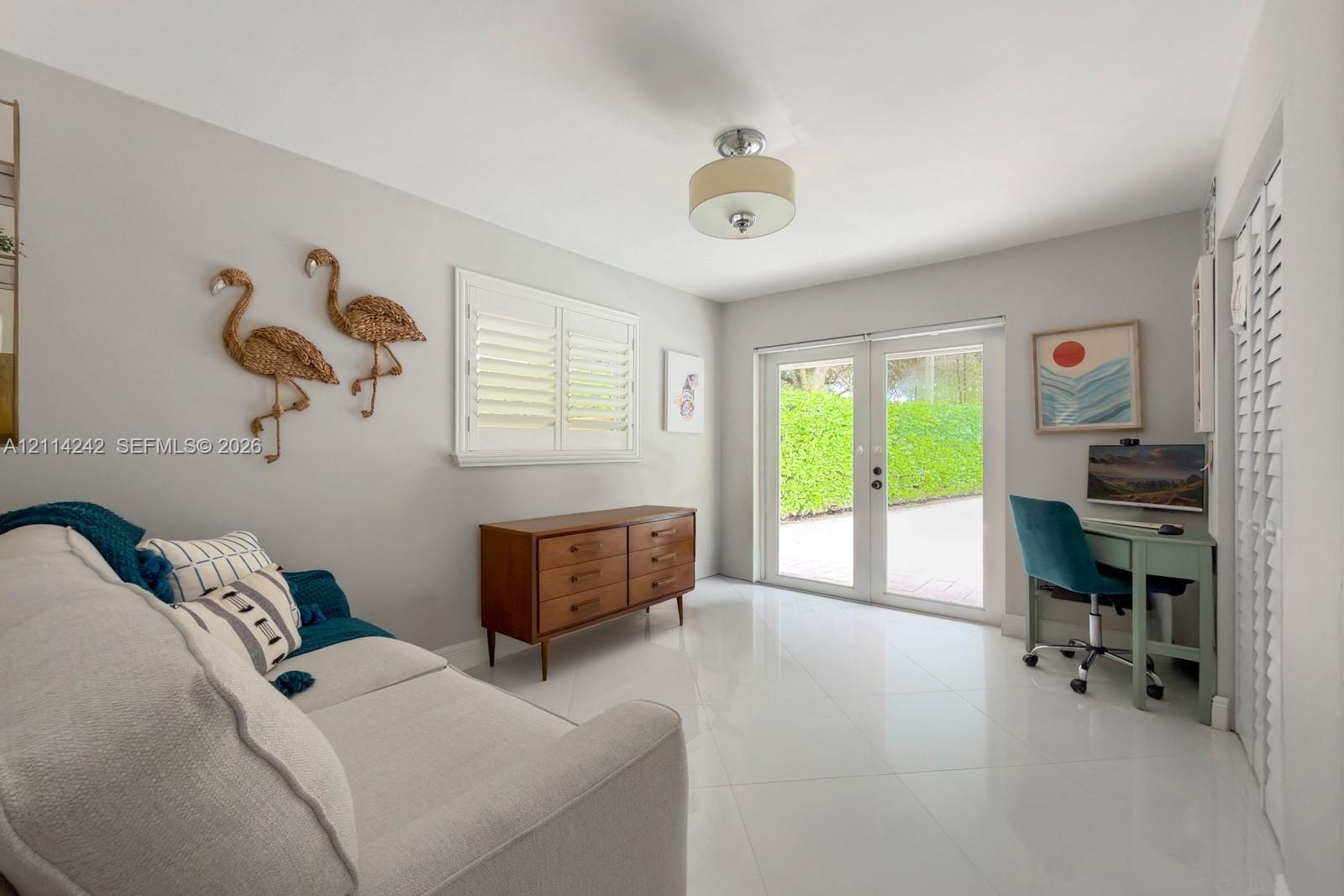 Glossy tile flooring, double glass-paneled exterior doors, plantation shutters, and a ceiling-mounted drum light fixture