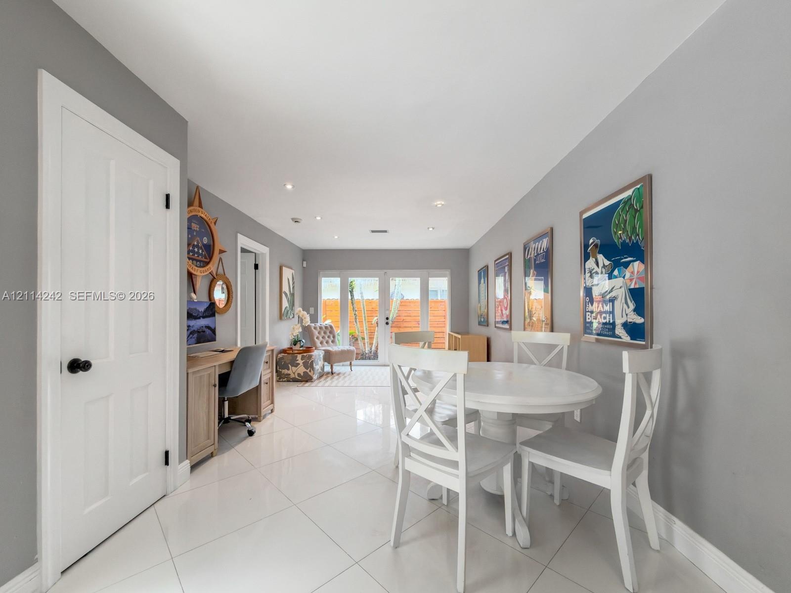 Interior space featuring large-format polished tile flooring, recessed lighting, and double glass-paned doors leading to an outdoor area