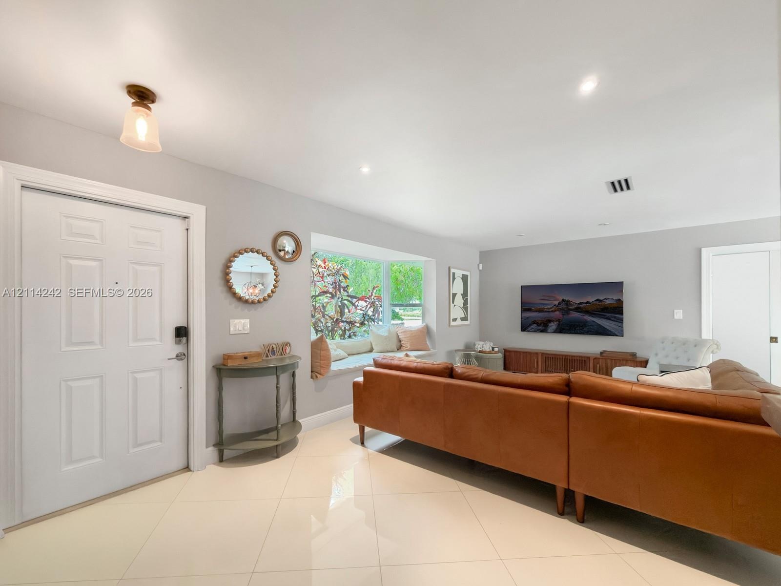 Living space featuring large-format tile flooring, recessed lighting, and a built-in window seat