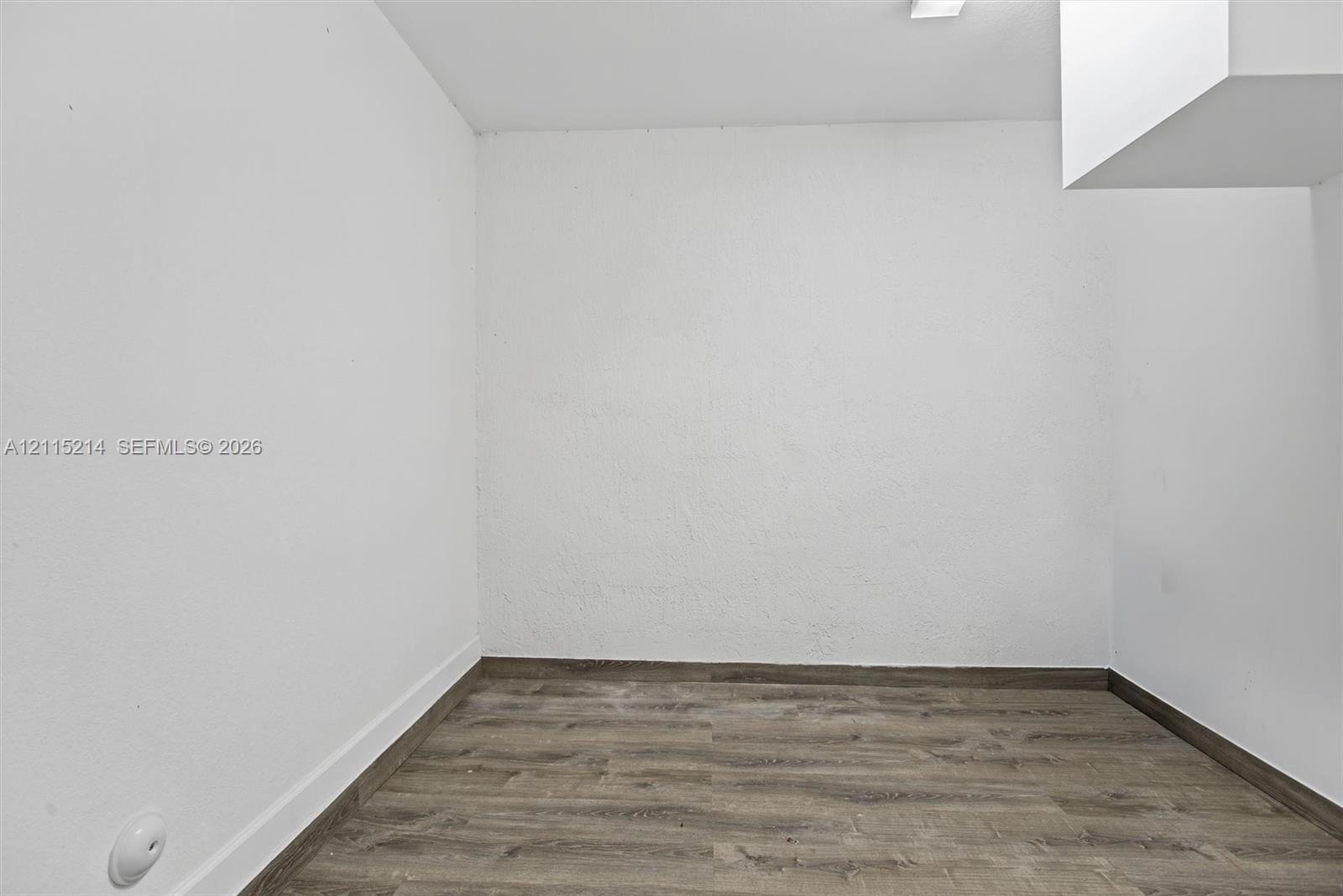Neutral-toned wood-finish flooring and smooth-textured white walls