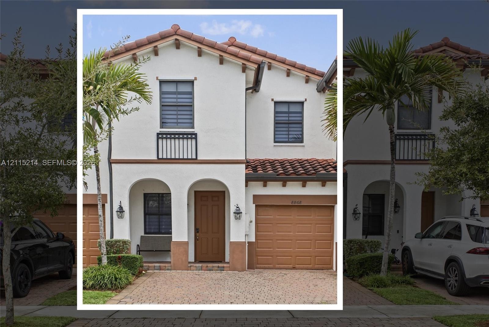 Stucco exterior featuring arched entryway detailing, red-tiled roof, paver driveway, and a single-car garage